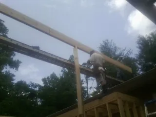 Carpenter setting a ridge beam over a new addition frame — Ice Dam Removal by Roofing Brothers in Juneau