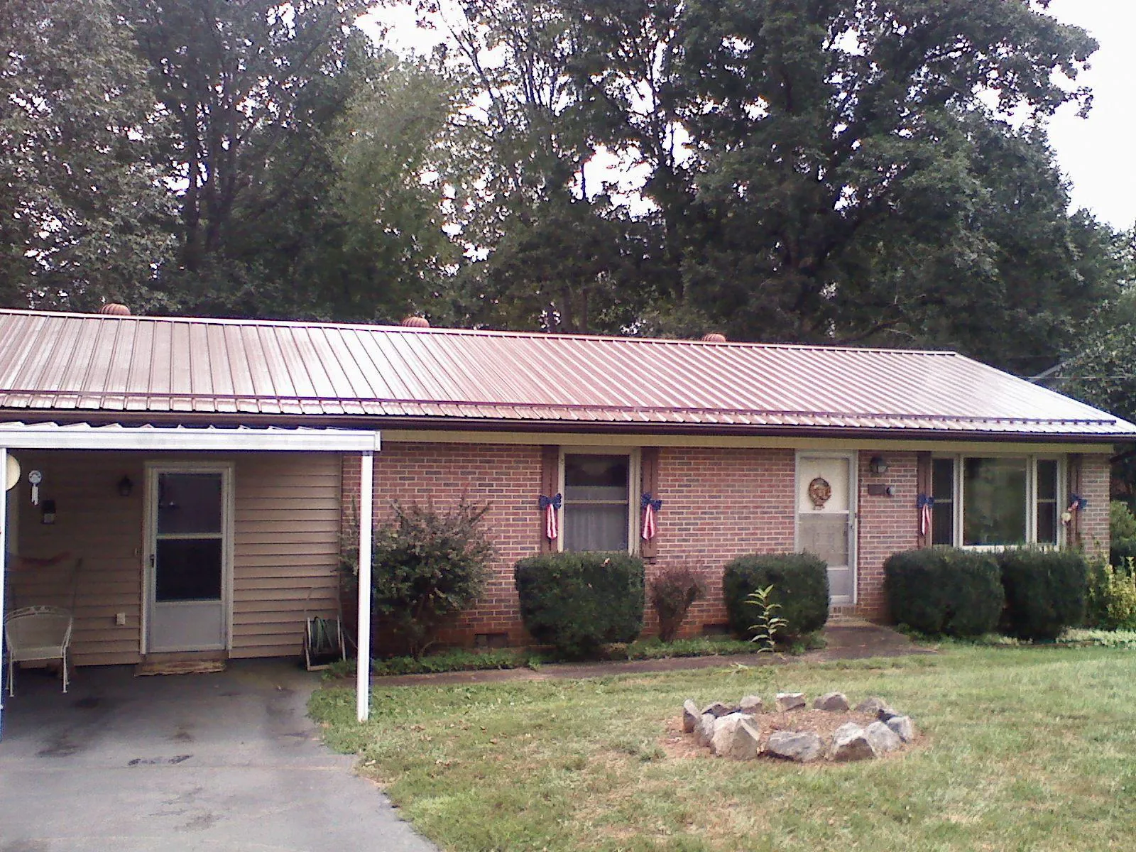 Bronze metal roof and carport on a brick ranch home — Roof Repair work by our crew in Juneau